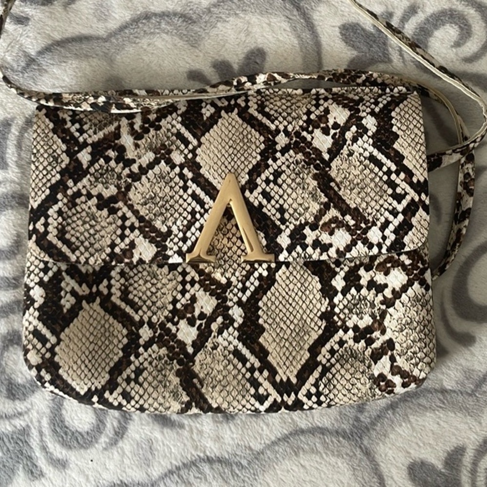 Cute little gem of a purse in snakeskin print. Small but mighty, fun, accessory